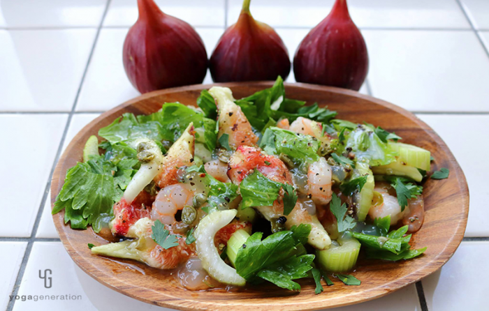 木の皿に乗ったイチジクとセロリ、エビのサラダ