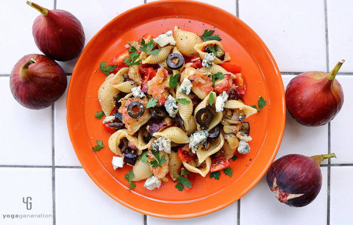 オレンジの皿に乗ったイチジクとナス、ブルーチーズのパスタ・サラダ