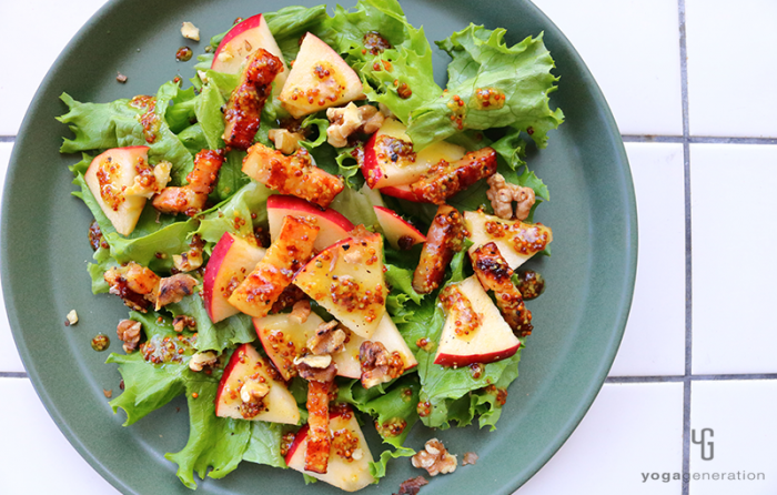 シックな緑色の器に入ったリンゴとベーコンのサラダ