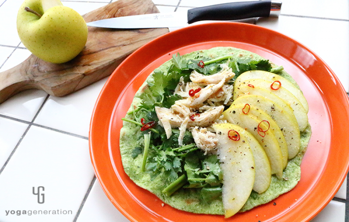 オレンジの皿に盛った青リンゴとハーブチキンのサラダ