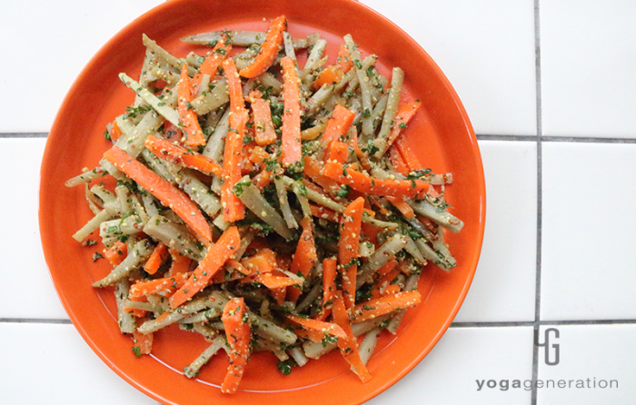 オレンジの皿に盛り付けたゴボウとニンジンのハニーマスタード・サラダ