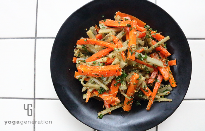 黒い皿に盛り付けたゴボウとニンジンのハニーマスタード・サラダ