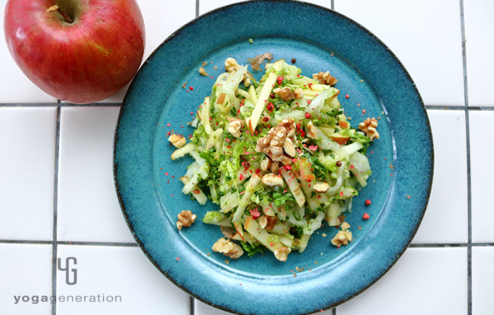 翡翠色の皿に盛り付けた白菜とリンゴとクルミのクリスピー・サラダ