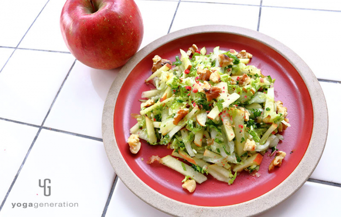 赤い皿に盛り付けた白菜とリンゴとクルミのクリスピー・サラダ