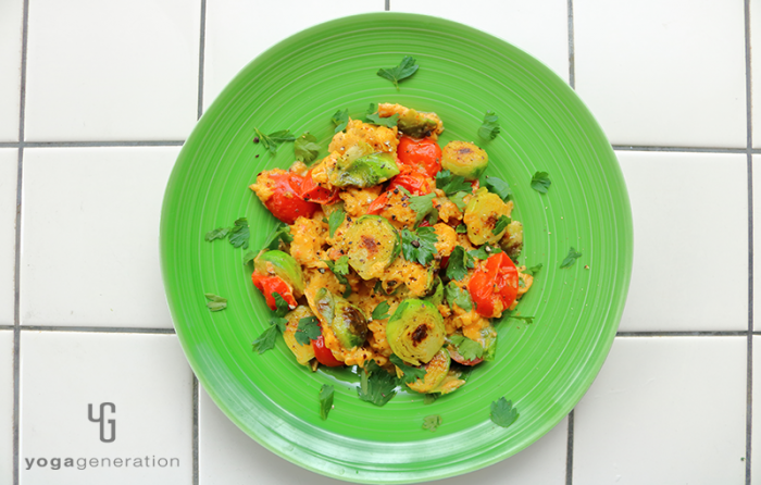 緑の器に入った芽キャベツとトマト入りメキシカンなスクランブルエッグ