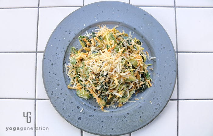 濃いグレーの皿に盛り付けたショウガたっぷりキュウリとココナッツのピーナッツクリーム・ドレッシング和え