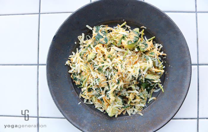 黒の皿に盛り付けたショウガたっぷりキュウリとココナッツのピーナッツクリーム・ドレッシング和え