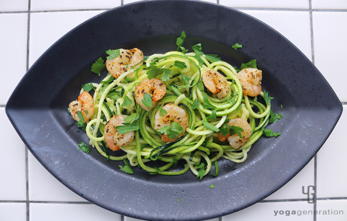 黒い皿に乗せたズッキーニとエビのガーリックレモン・サラダ
