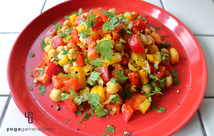 赤い皿に盛り付けたヒヨコ豆とパプリカのスパイシー・カラフルサラダ