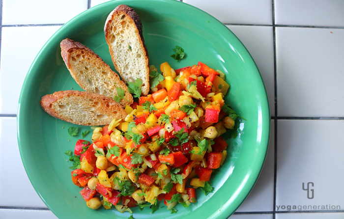 緑の皿に盛り付けたヒヨコ豆とパプリカのスパイシー・カラフルサラダ