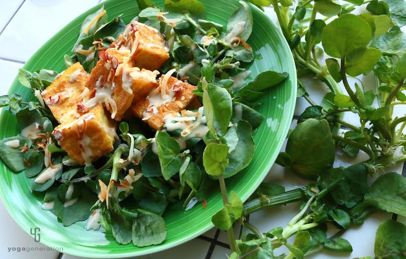 緑の皿に乗ったクレソンと厚揚げのサラダ