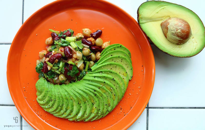 赤い皿に乗ったアボカドと豆のサラダ