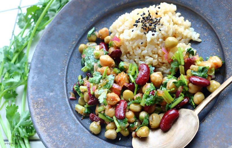 黒の皿に乗ったご飯と豆のサラダ