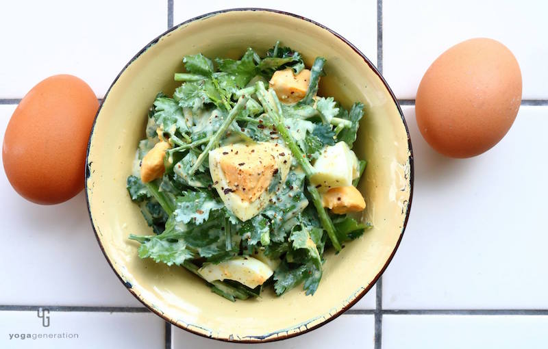 クリーム色の器に入ったパクチーとゆで卵のサラダ