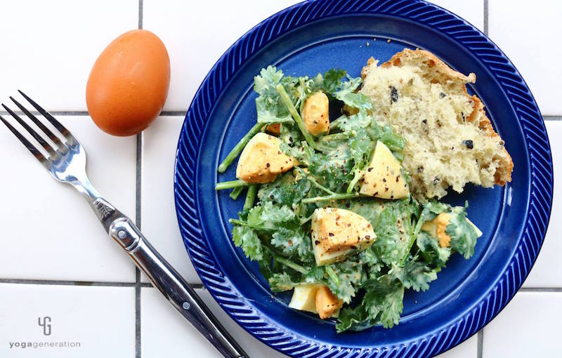 藍色の皿のサラダに乗ったパクチーとゆで卵パン添え