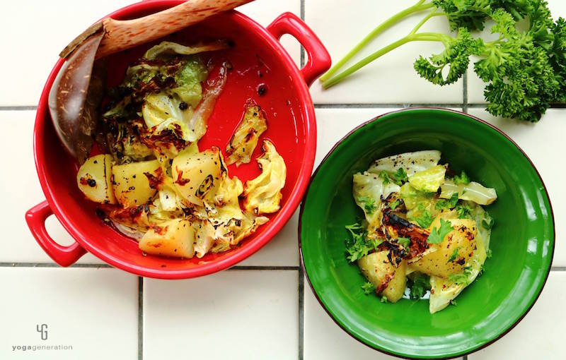 赤の器から緑の器にとりわけたキャベツとジャガイモのアンチョビグリル