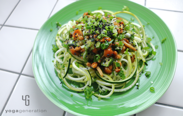 緑の皿に盛り付けたナメコ納豆ソースでズッキーニ・ヌードル