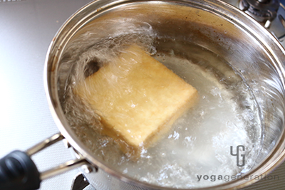 厚揚げの油抜きをしているところ