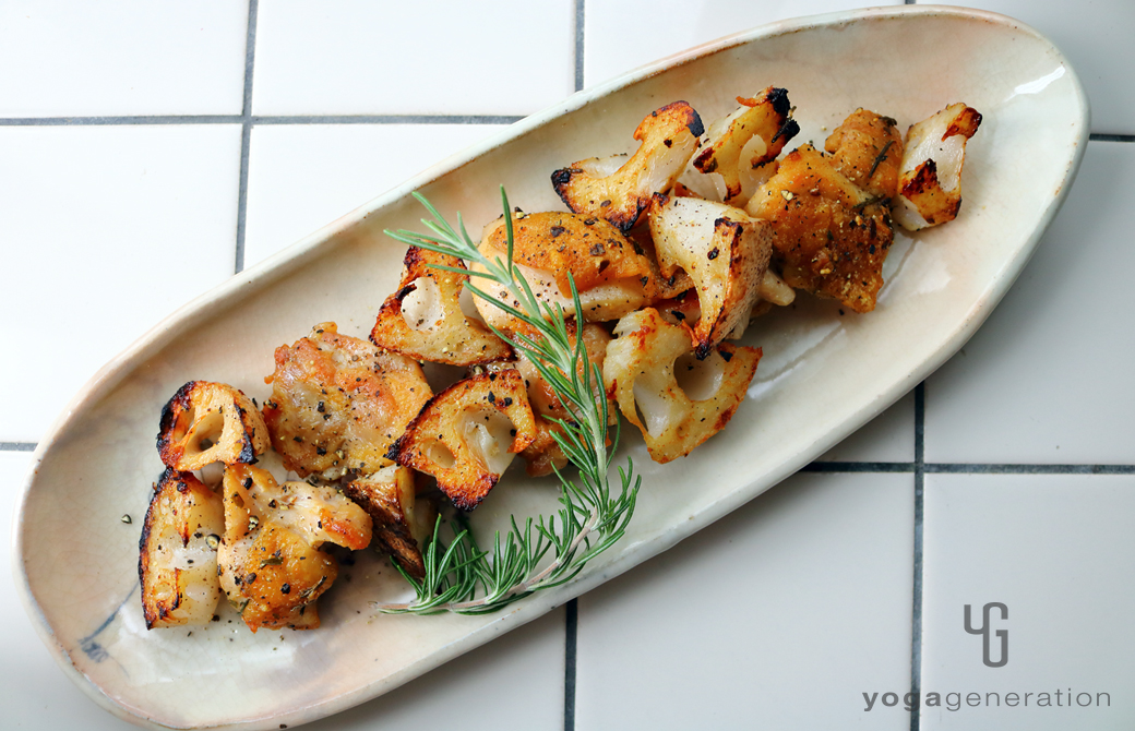 淡いピンクの器に盛りつけたローズマリー香る鶏肉とレンコンのガーリック炒め