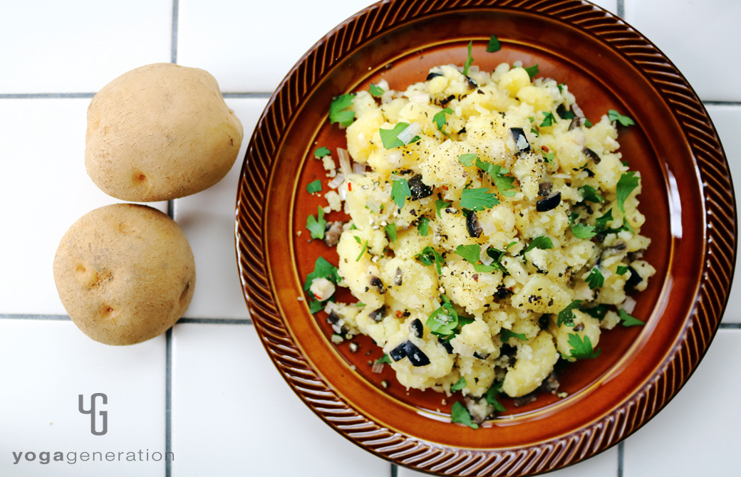 濃いブラウンの皿に盛りつけたラッキョウと黒オリーブのポテトサラダ
