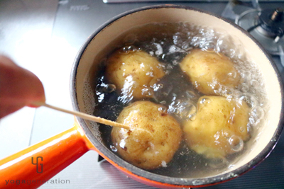 ジャガイモに竹串を通して茹で加減を確認する