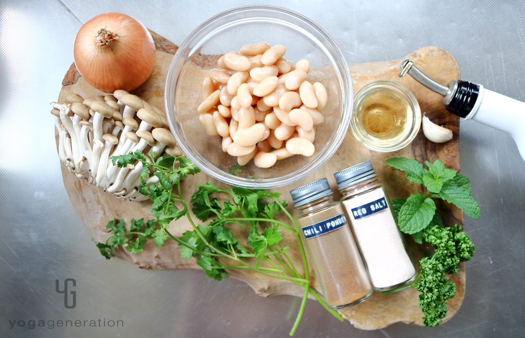 木製カットボードの上のシメジや白インゲン豆などの材料