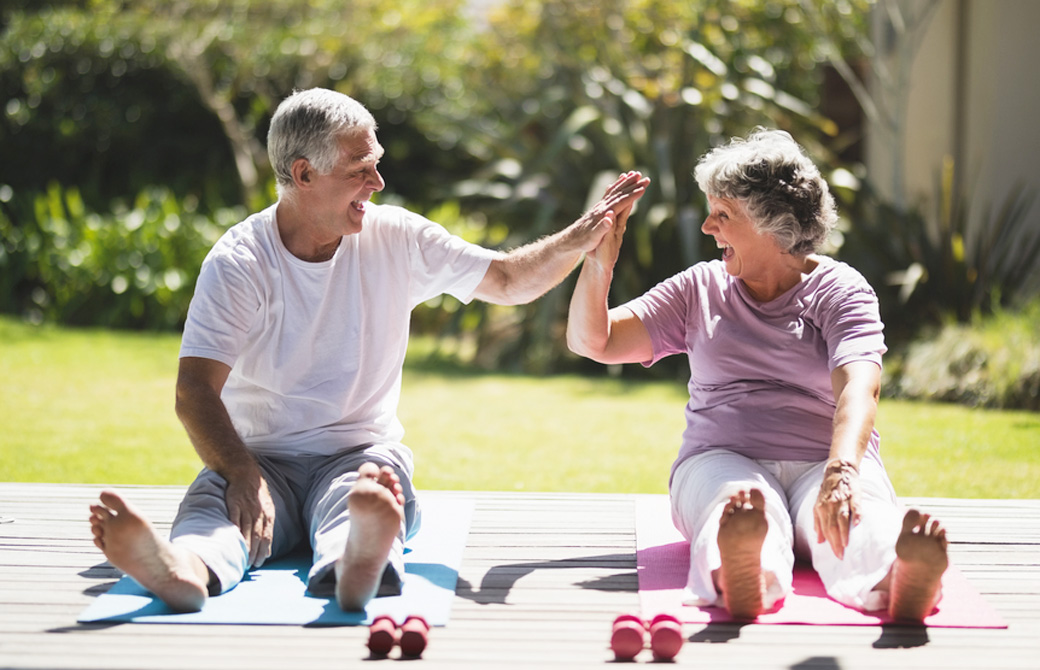 高齢者の男女がヨガをしている