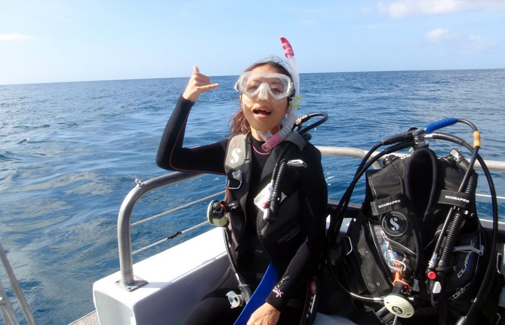 Mahokoが初スキューバダイビングで船上でポーズをとっている