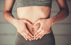 お腹両手をあてる女性