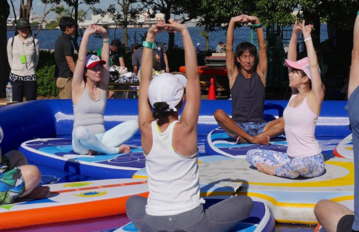 屋外でボードの上でヨガをしている様子