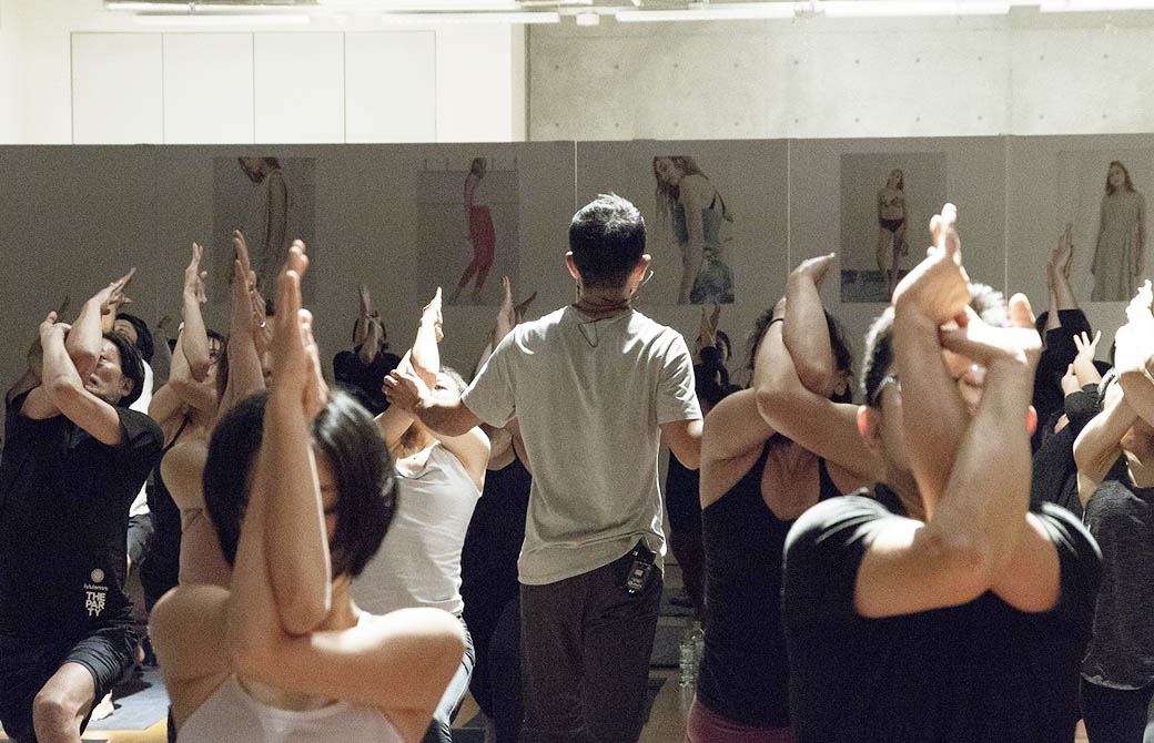 山本俊郎先生の後ろ姿とガルダアーサナをする参加者