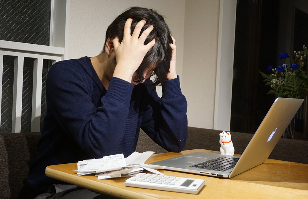 レシートの山に頭を抱えるヨガジェネレーション・エンジニア吉川祐生