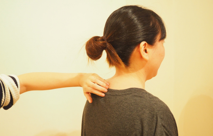 スタッフKの背中の骨をたたいている