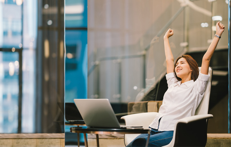 オフィスで座ったまま伸びをする女性