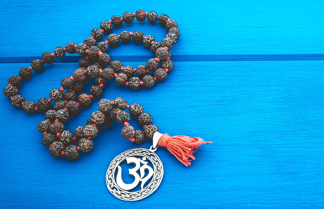 オームのマークのペンダントが青い机の上に置かれた写真