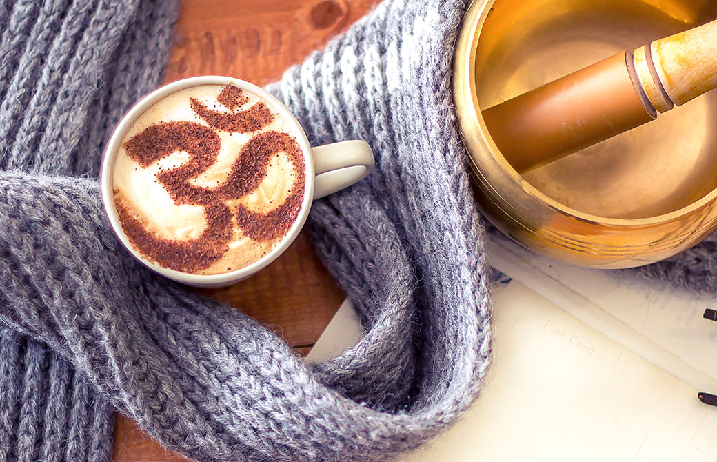 オームのマークが書かれた飲み物とグレーのマフラーとシンギングボールの写真