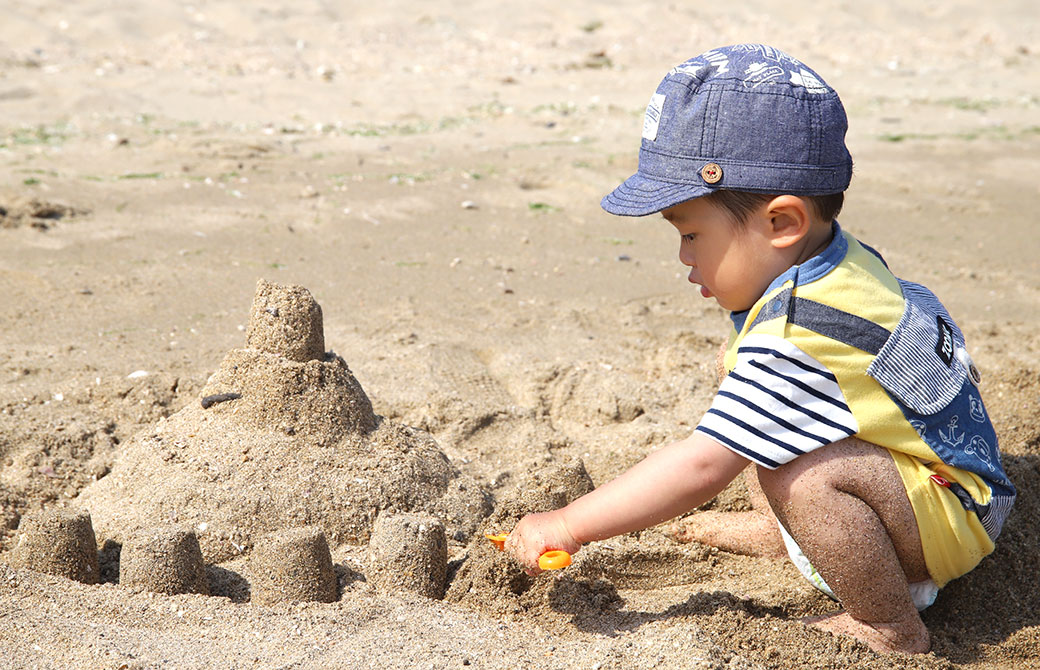 kaya息子が海でお城を作って遊んでいる写真
