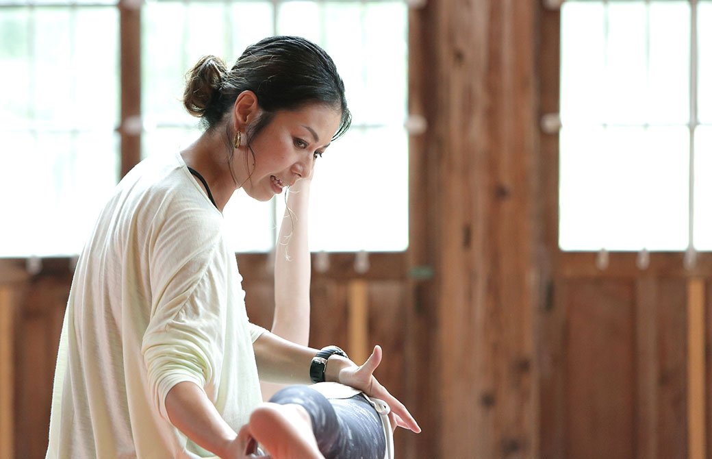 田村佳世さんがヨガクラスでアジャストをしている写真