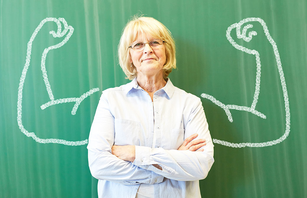 女性が腕の筋肉が描かれた黒板の前に経っている写真