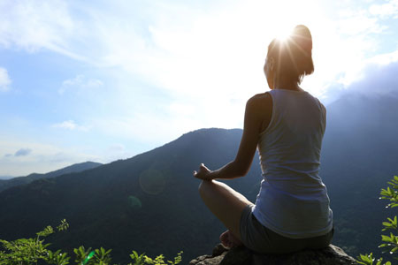 山に向かって安楽座で座る女性