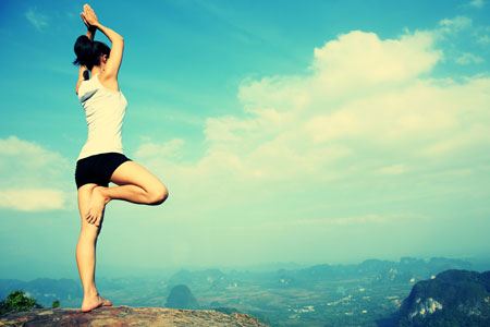 頂上で木のポーズをする女性