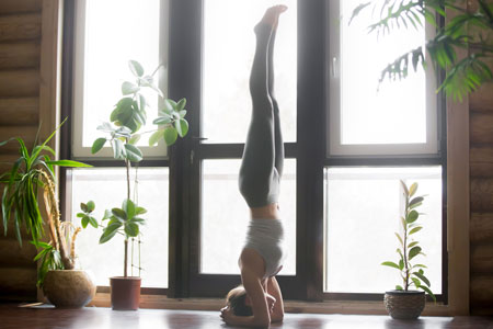 頭立ちのポーズをする女性