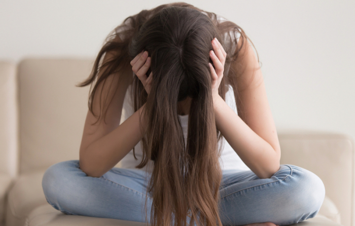 頭を抱えて下を向いている女性