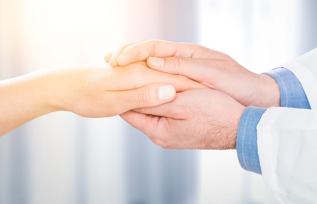 男性が女性の手を握っている
