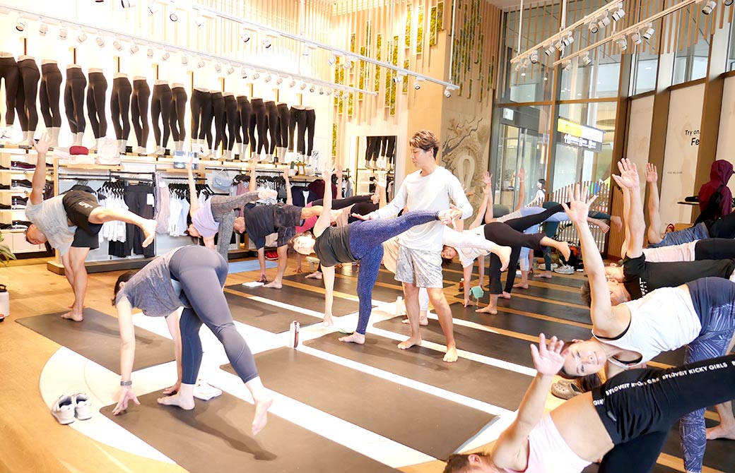 アルダチャンドラアーサナを練習する生徒さんとアジャストする空平先生