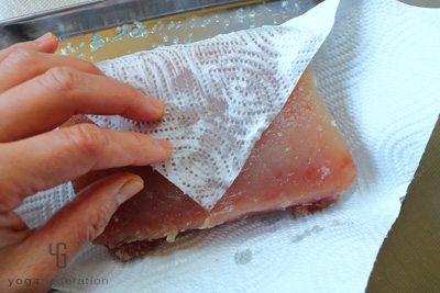 マグロから出た水気を拭き取る
