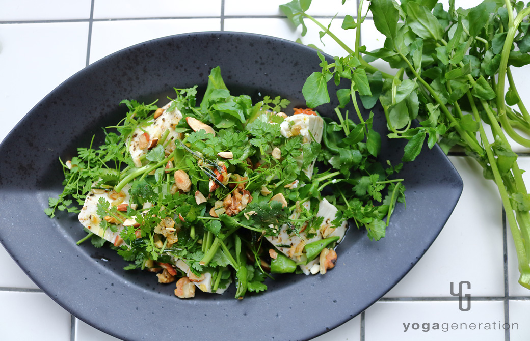 黒色の皿に盛りつけたガーリック・レモンドレッシングでクレソンとお豆腐のサラダ