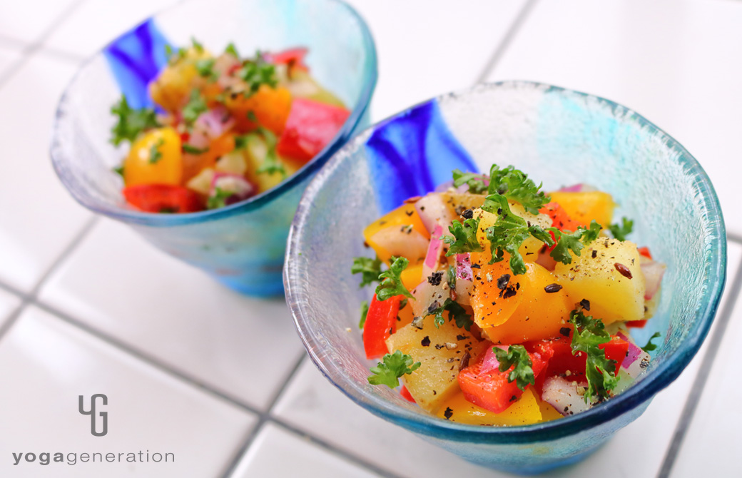 ガラス製のターコイズブルーの器に盛りつけたビタミンカラーの揚げじゃがサラダ