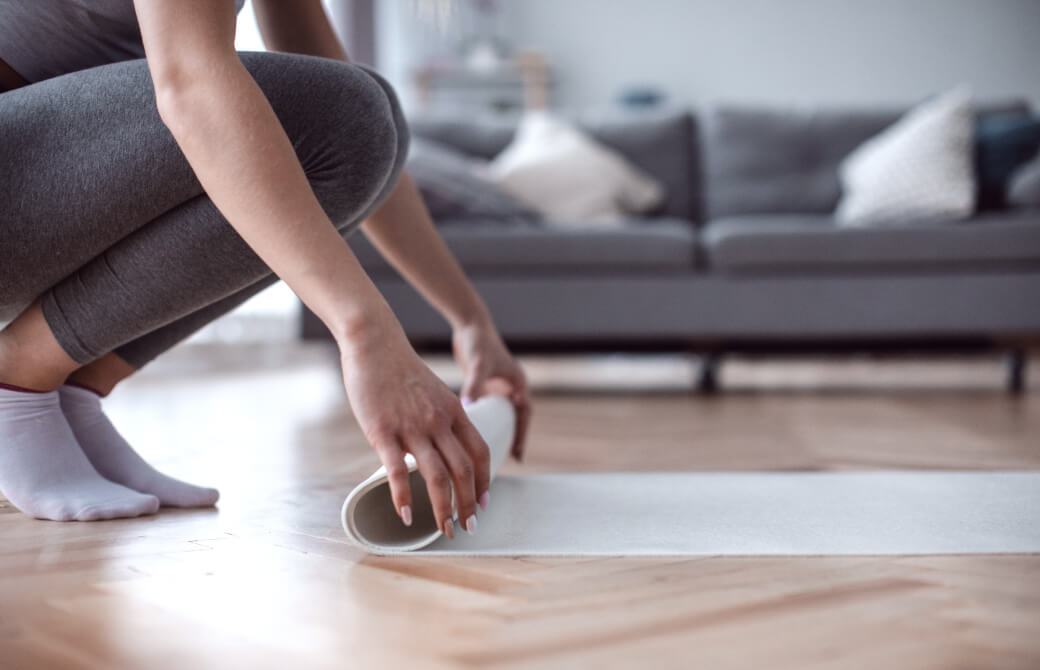 自宅でヨガマットを広げる