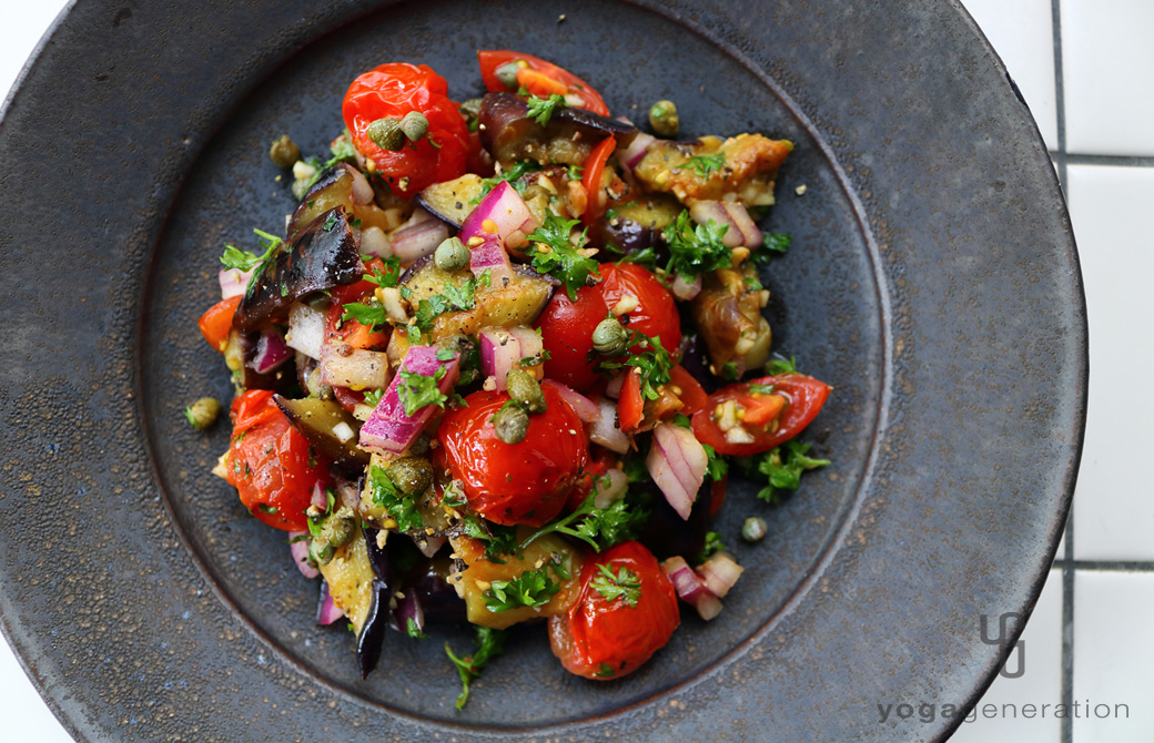 黒い皿に盛りつけたケイパーを効かせたナスとトマトのマリネ